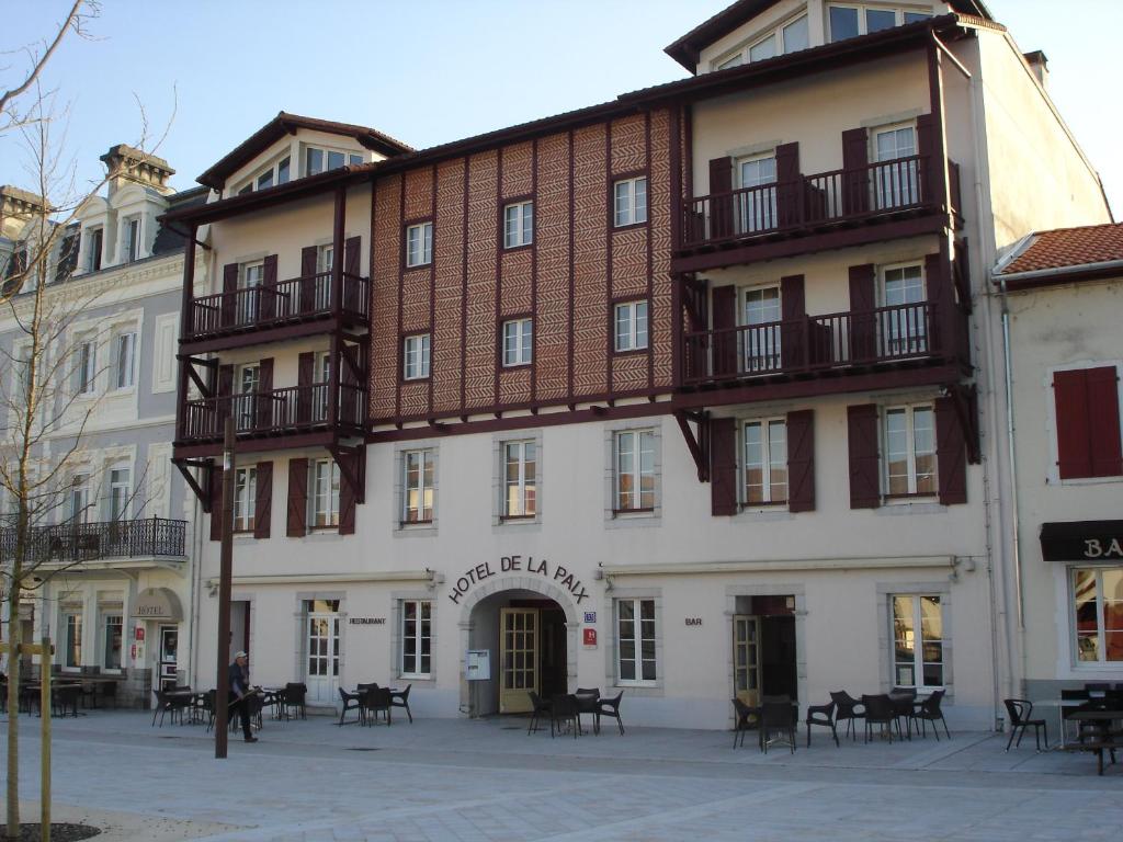 un gran edificio blanco con balcones en una calle en Hôtel-Restaurant de La Paix, en Saint-Palais