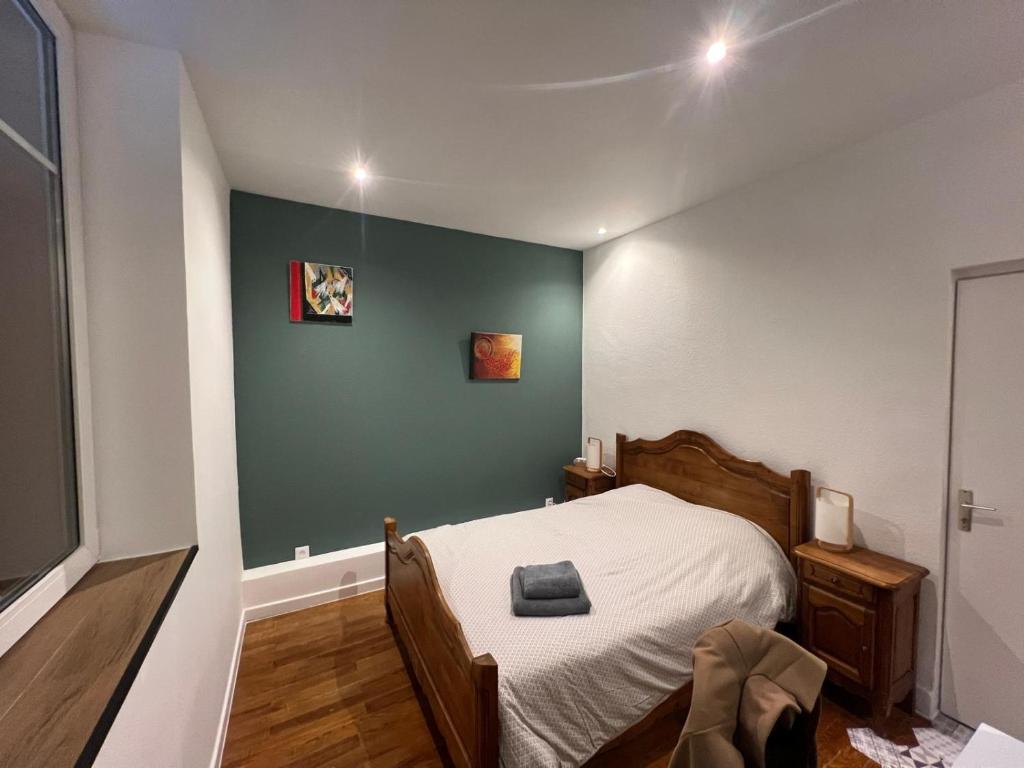 a bedroom with a bed and a green wall at F2 chez Cathy et Mike wittenheim in Wittenheim