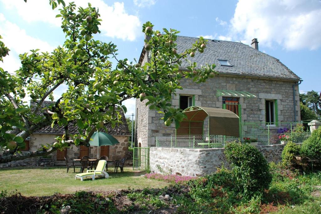 une maison en pierre avec une table et des chaises devant elle dans l'établissement Maison de charme à la campagne, à Espagnac