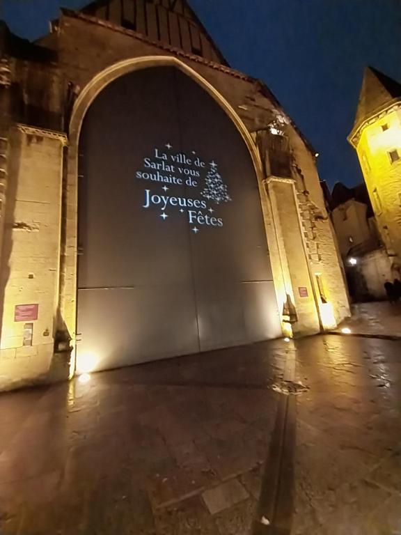 an arch with writing on the side of a building at Gîte T3 Sarlat d'oie in Sarlat-la-Canéda