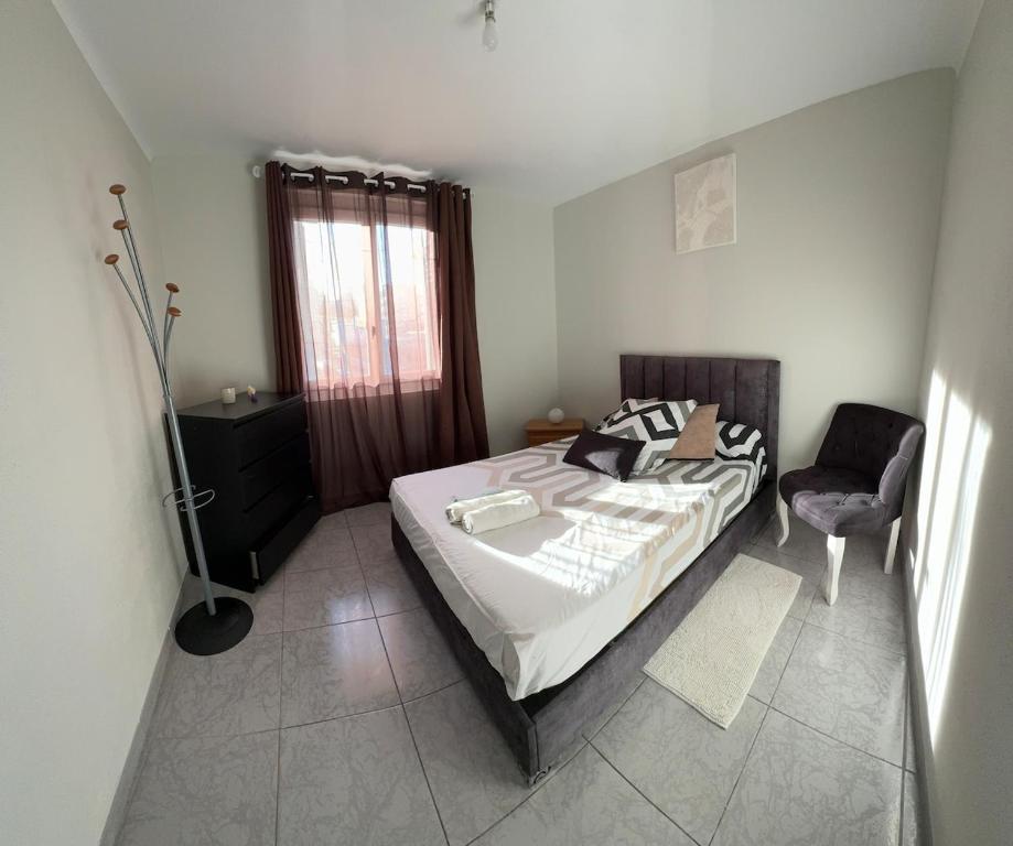 une chambre avec un grand lit et une chaise dans l'établissement Charmant appartement à proximité de la gare, à Marseille