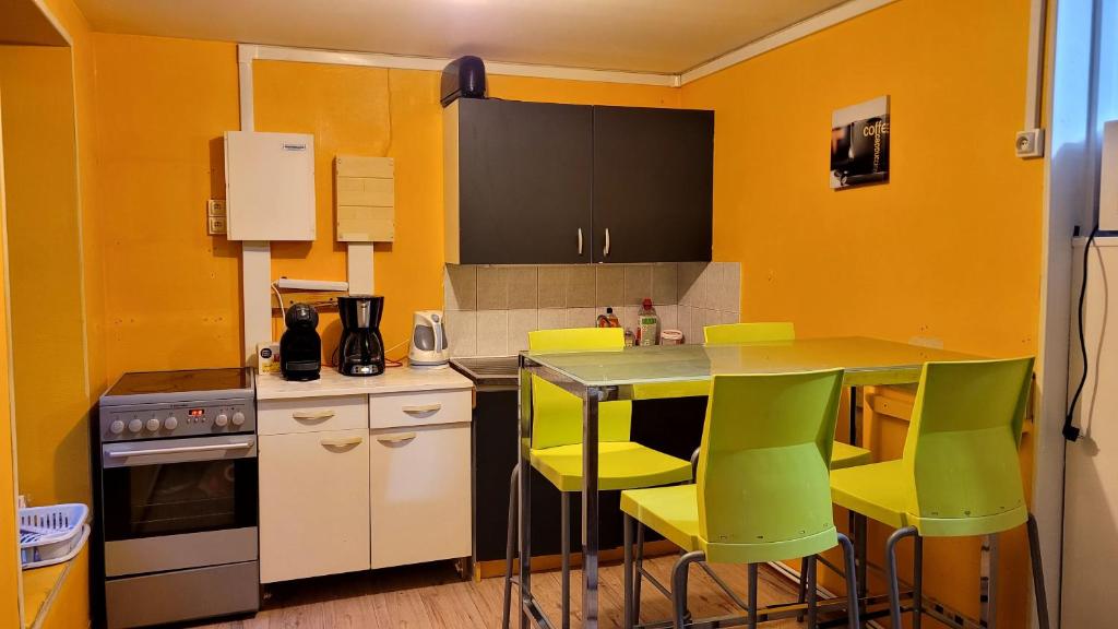 une cuisine avec des murs jaunes et une table avec des chaises jaunes dans l'établissement Appartement 3 chambres centre historique, au Puy-en-Velay