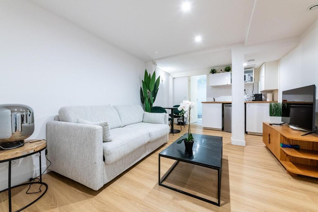 un salon avec un canapé et une table dans l'établissement Avenue Breteuil Family - 11 pers - Unique - Cosy, à Paris
