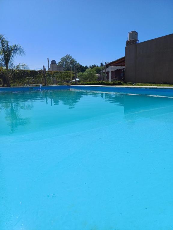 a large swimming pool with blue water at Casa quinta Capibara in Concepción del Uruguay