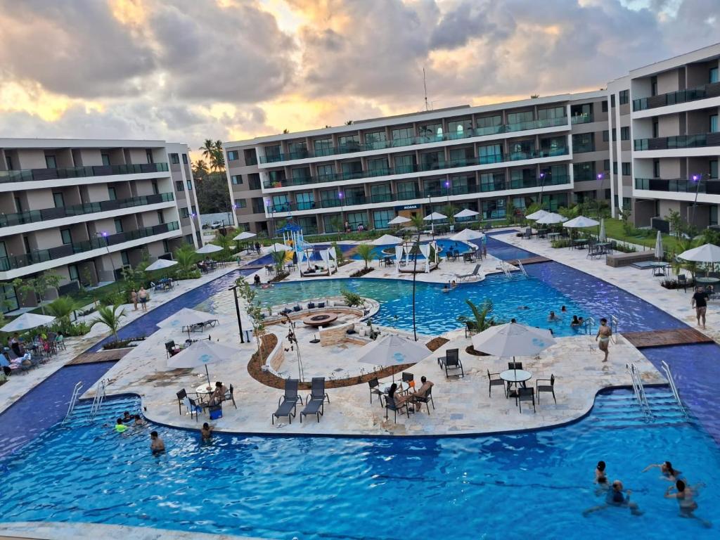 a large swimming pool with people in a resort at Malia Beach 302 D - Muro Alto - Porto de Galinhas in Porto De Galinhas