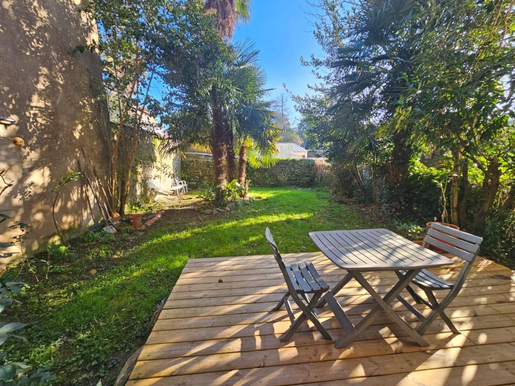 a wooden table and two chairs on a patio at proche centre calme jardin privé in Nantes