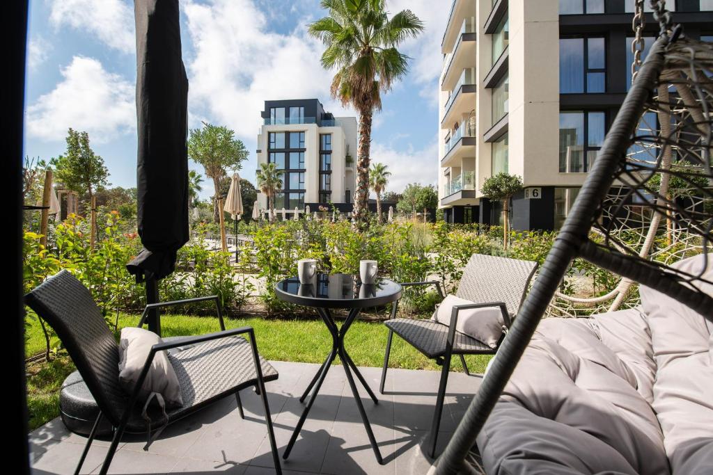 un patio con tavolo e sedie e un edificio di Pool view Apartment Azur Deluxe Resort & Spa a Varna