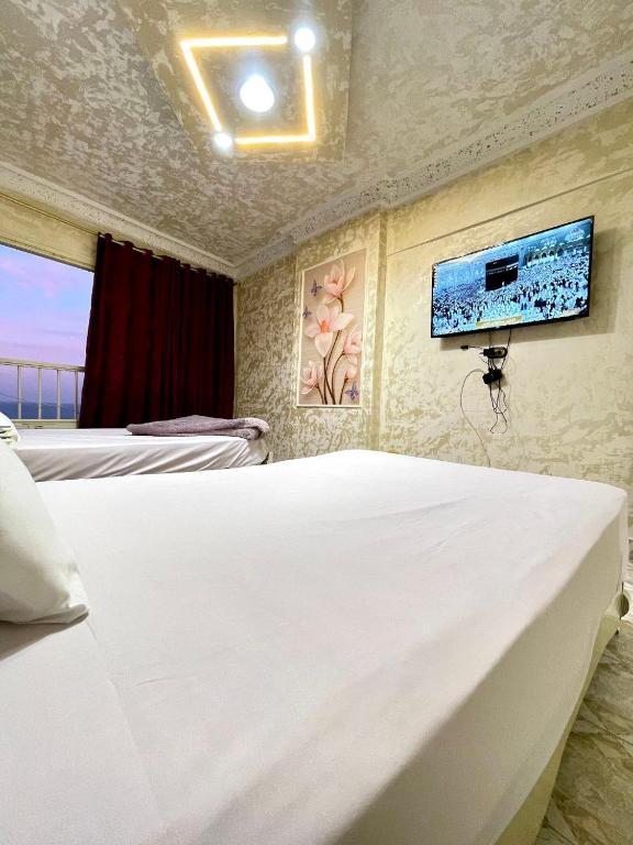 a bedroom with two beds and a tv on the wall at Sporting star in Alexandria