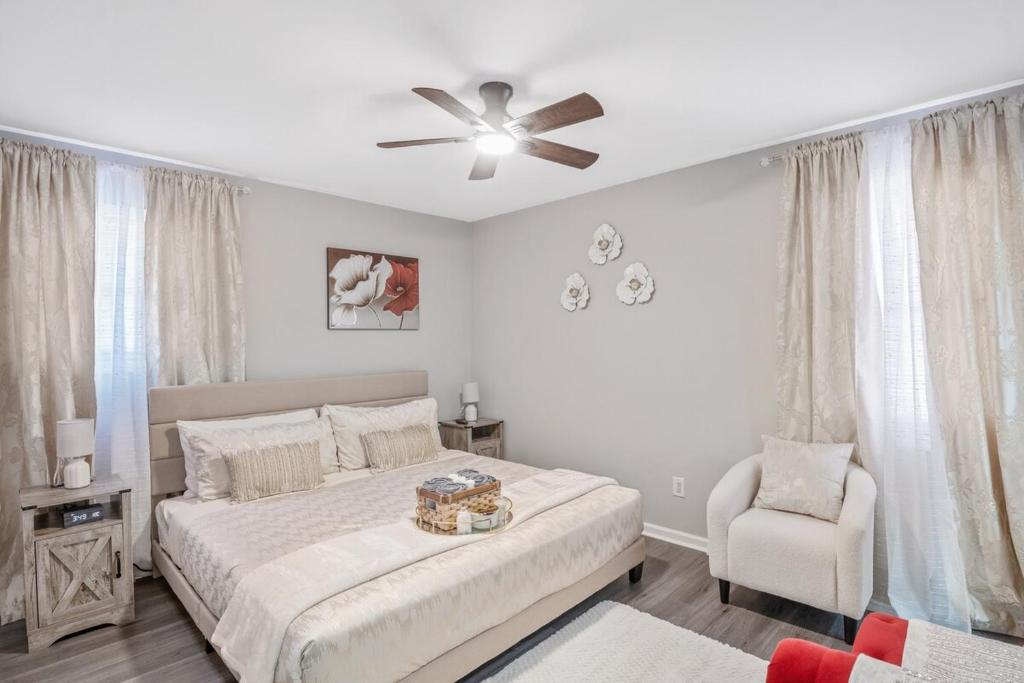 a bedroom with a bed and a ceiling fan and a chair at Charming Retreat with Pool Table in Chesterfield! in Chesterfield