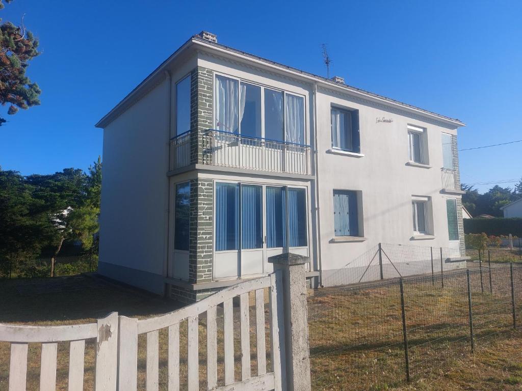 ein weißes Haus mit einem Zaun davor in der Unterkunft Notre Dame de Monts proche plage in Notre-Dame-de-Monts