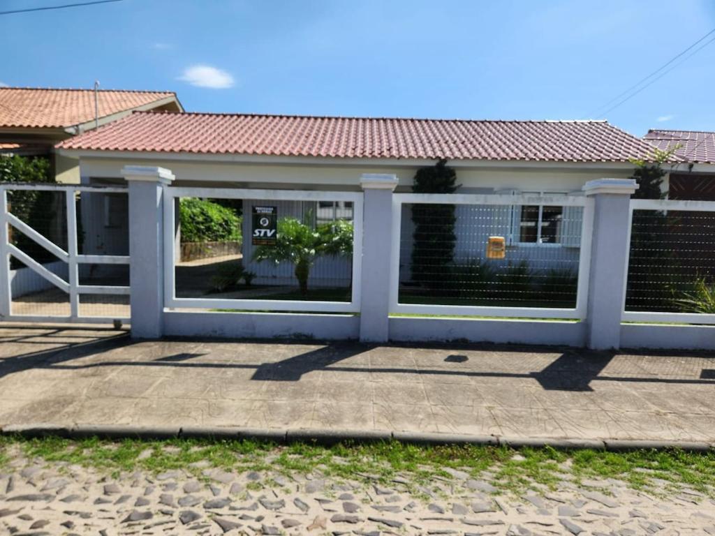 a house with a gate in front of it at Casa veraneio em Xangri-Lá in Xangri-lá