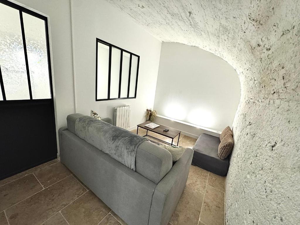 - un salon avec un canapé gris et un mur en pierre dans l'établissement Spacieux et atypique avec place de parking devant la porte d'entrée, à Orléans