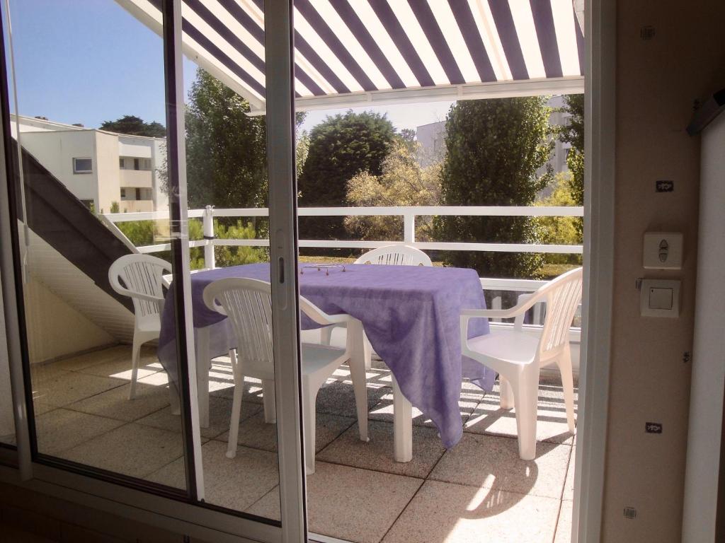 une table et des chaises sur un balcon avec une nappe violette dans l'établissement Relax à Carnac, à Carnac