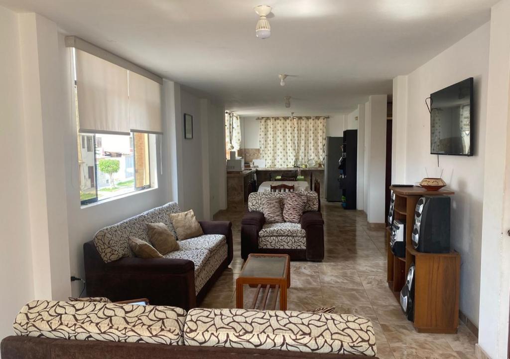 ein Wohnzimmer mit zwei Sofas und einem Fernseher in der Unterkunft Departamento cerca a Cerro Azul in Hualcará