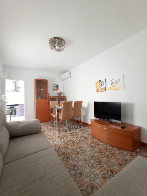 a living room with a couch and a tv and a table at Jaén Ways in Jaén