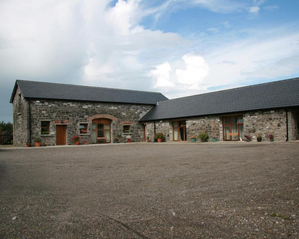 un edificio in pietra con un vialetto di fronte di Cowshed - Duffys Ballybin 4-star a Ashbourne