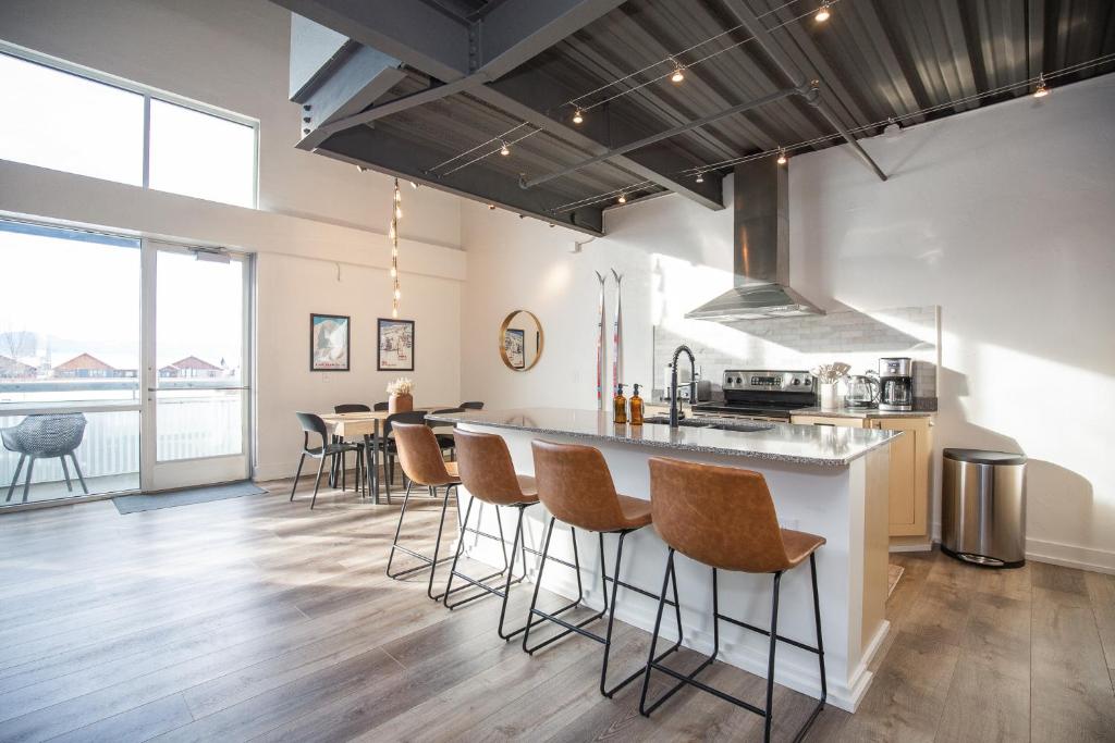 a kitchen with a counter and stools in a room at Bozeman Basecamp in Bozeman