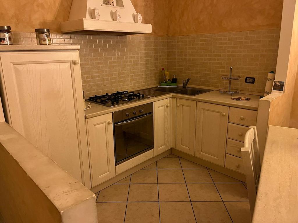 a kitchen with white cabinets and a stove top oven at Albenga La Romantica in Albenga