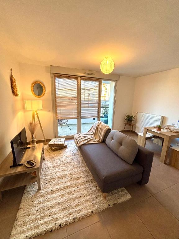 un salon avec un canapé et une table dans l'établissement Proche Genève - Cosy Appartement, à Reignier-Ésery