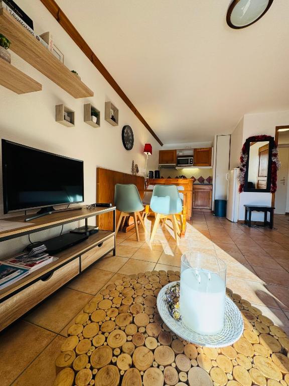 un salon avec une télévision et une table avec une bougie dans l'établissement Appartement Vu Mont Blanc parking Terrasse, à Chamonix-Mont-Blanc