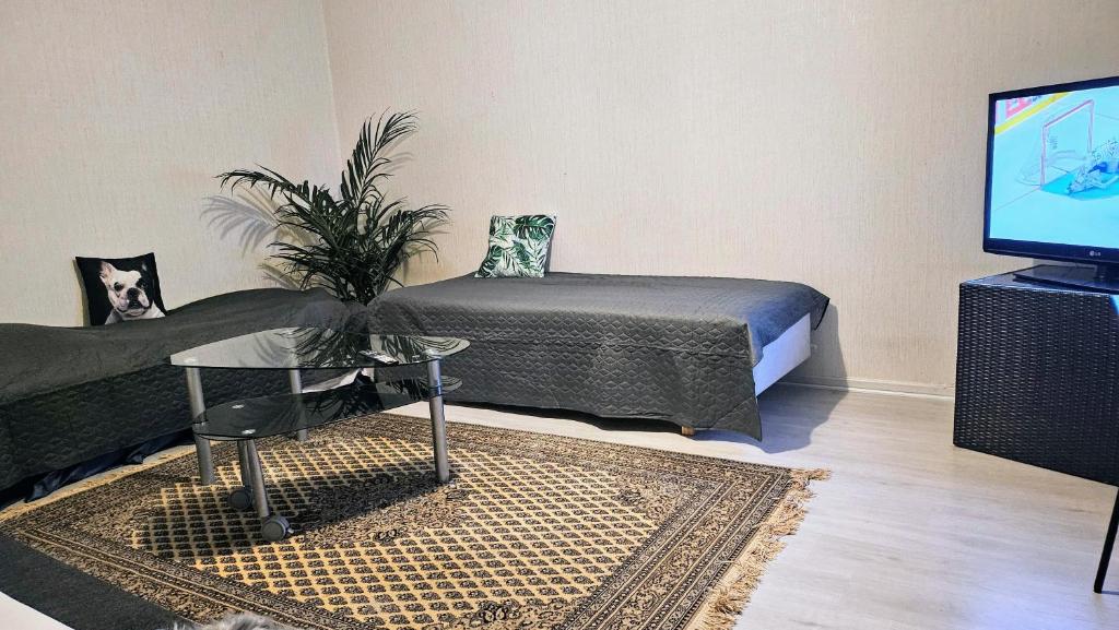 a bedroom with a bed and a table and a tv at Himos,Halli, Vehkaojan viihtyisä yksiö,A7 in Halli