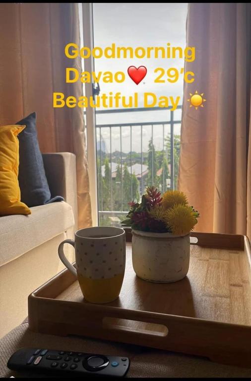 a coffee table with a coffee cup and plants on it at Convenient Davao Getaway in Davao City