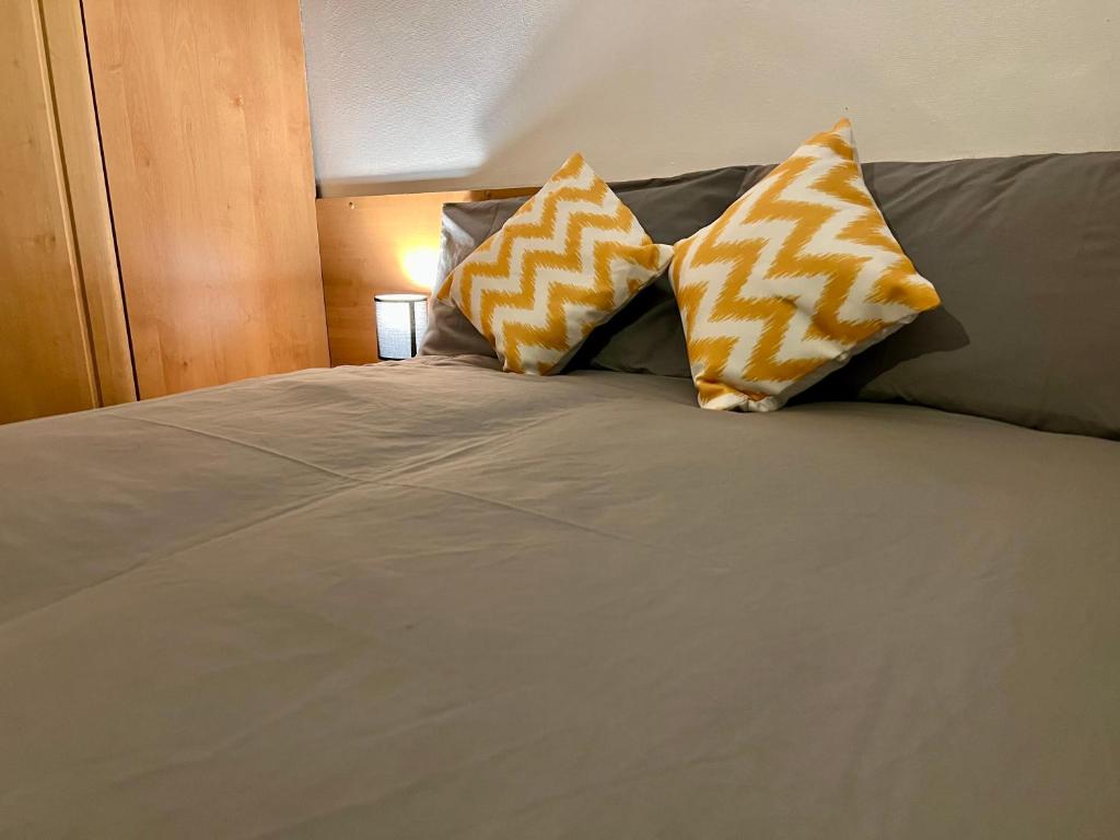 a bed with three pillows on top of it at Central Halifax Work & Retreat Base - Two bedroom house - sleeps up to 4 - free parking and internet in Halifax