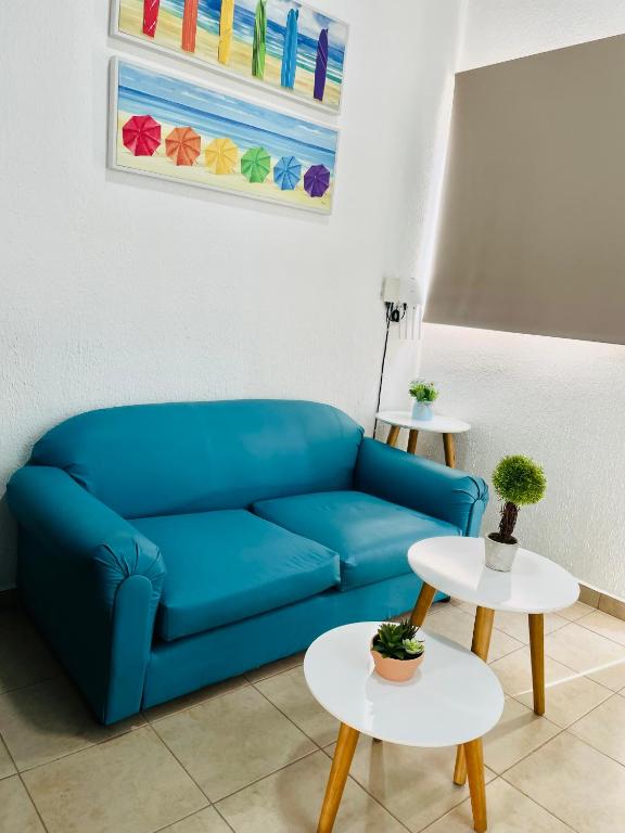 a blue couch in a living room with two tables at La Petite Santa Ana in Santa Ana