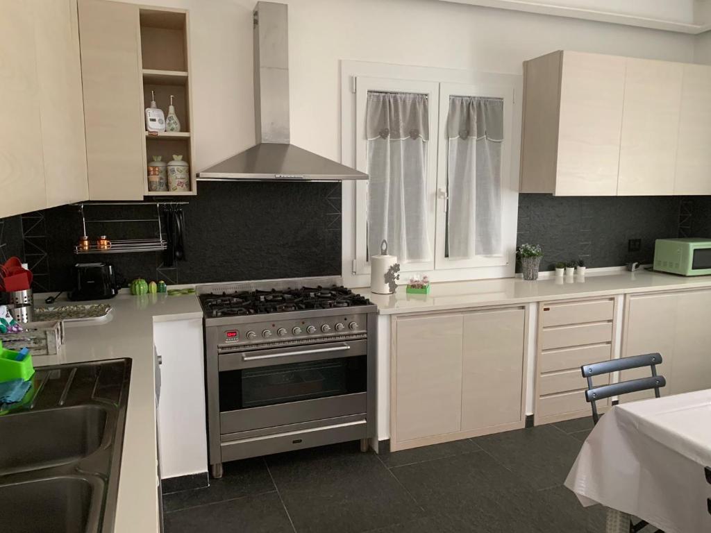 une cuisine avec des armoires blanches et un four à plaques de cuisson dans l'établissement Il Giardino di Marta - Villa privata con Piscina, à Contrada Maeggio