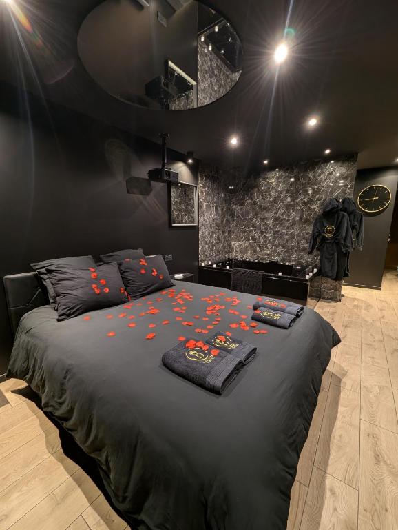 - une chambre avec un lit noir orné de fleurs dans l'établissement Escapade Romantique au Cœur du Vercors, à Villard-de-Lans