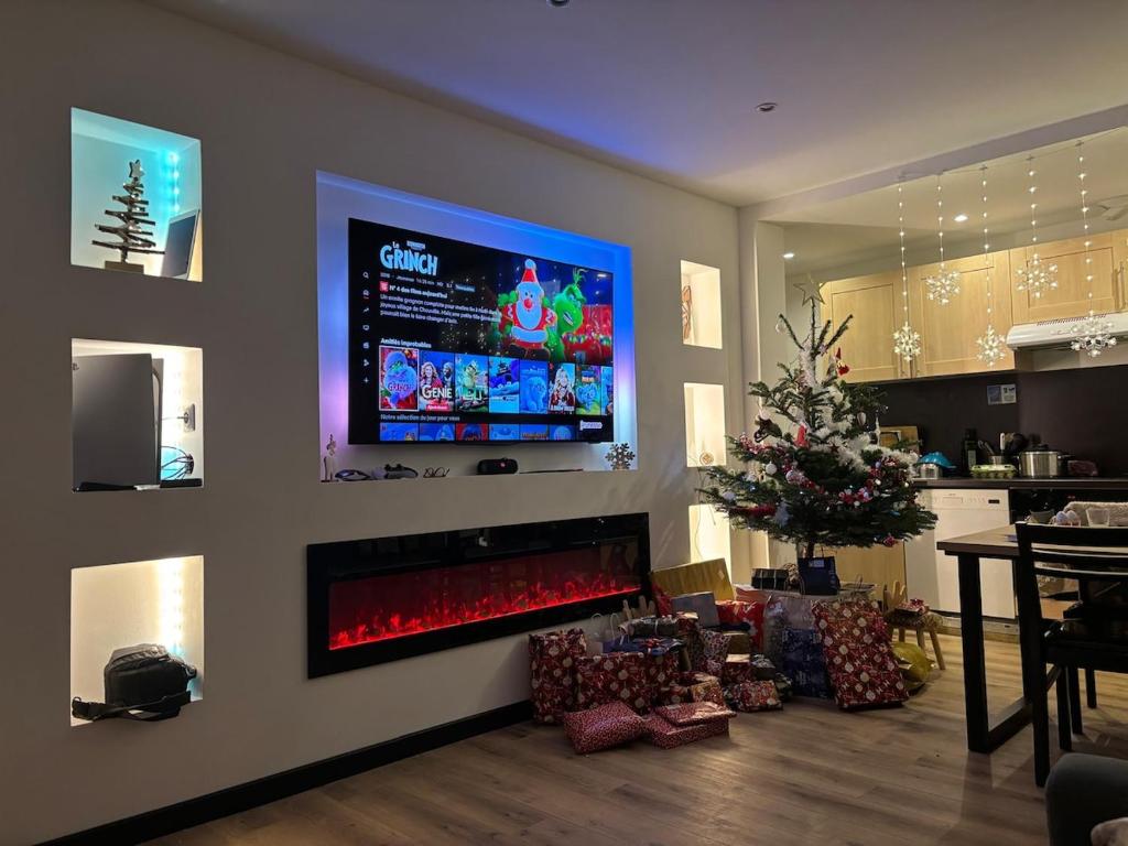 Elle comprend un salon avec une cheminée et une télévision murale. dans l'établissement Foux d 'Allos en rez de neige, à La Foux d'Allos