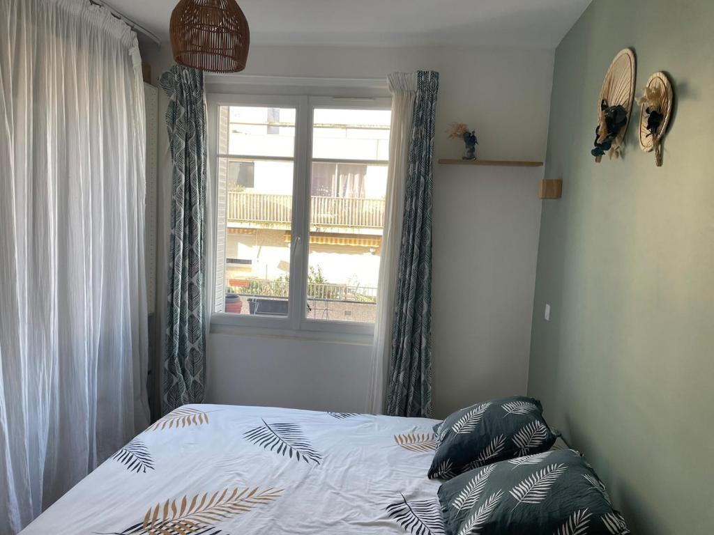 Ce lit se trouve dans une chambre dotée d'une fenêtre et d'un canapé-lit. dans l'établissement Appartment T2 Asnières Gare, à Asnières-sur-Seine