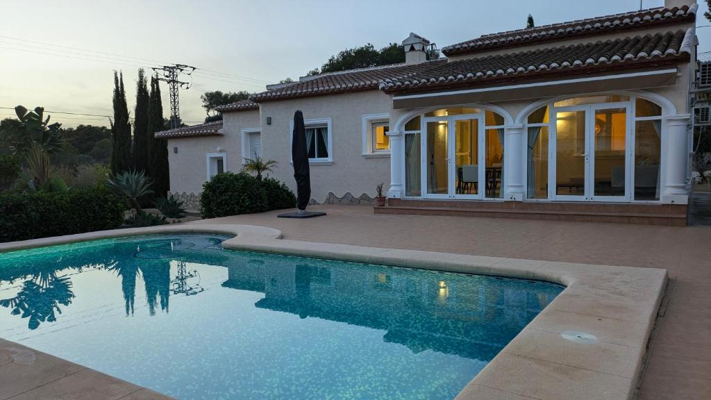 a house with a swimming pool in front of a house at Villa Carolina in Jávea