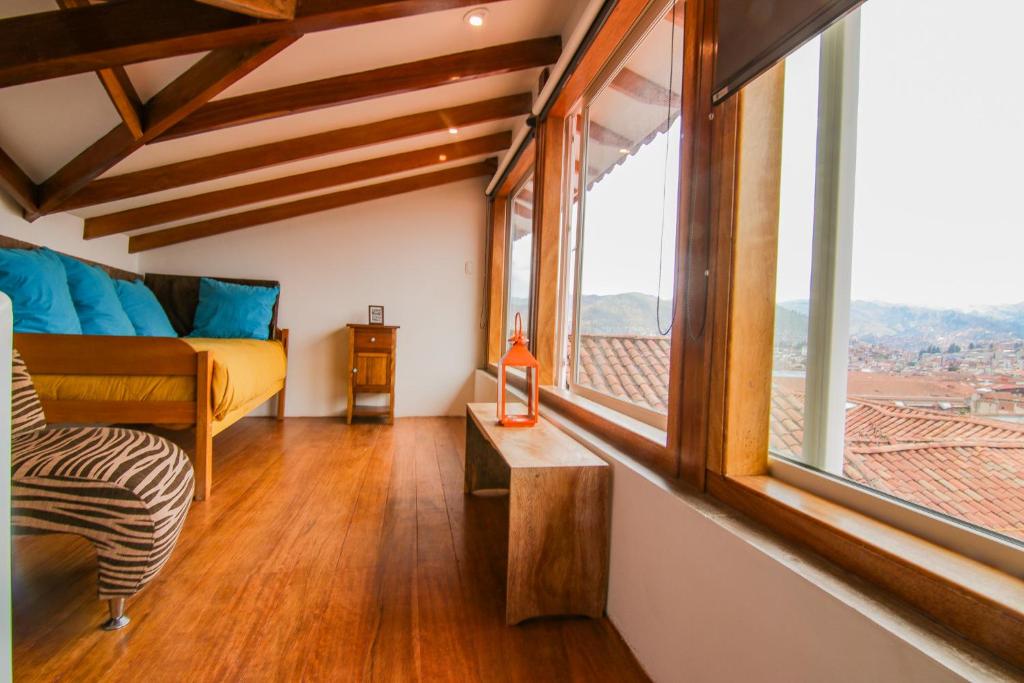 a room with a bed and a large window at QOSQO BELVEDERE, apartamento en Cuesta San Blas in Cusco