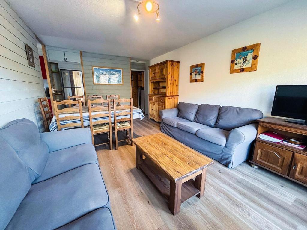 un salon avec des canapés bleus et une table dans l'établissement Résidence Oisans - Appartement pour 10 personnes MAE-4001, aux Menuires