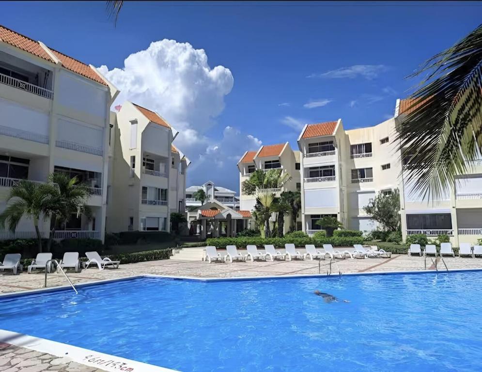 una piscina frente a unos edificios de apartamentos en Apartamento Playa Juan dolio, en Villas del Mar