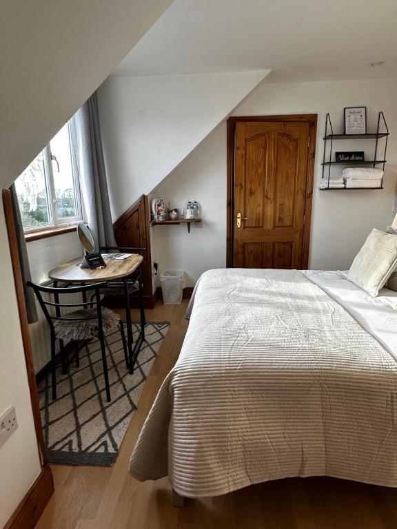 a bedroom with a bed and a desk with a laptop at Malahide Guest Rooms in Malahide