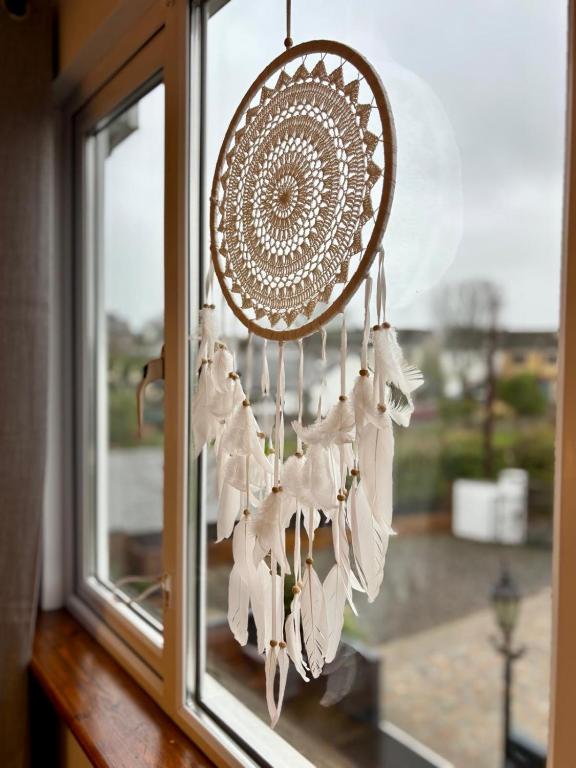 a dream catcher chandelier hanging from a window at Malahide Guest Rooms in Malahide