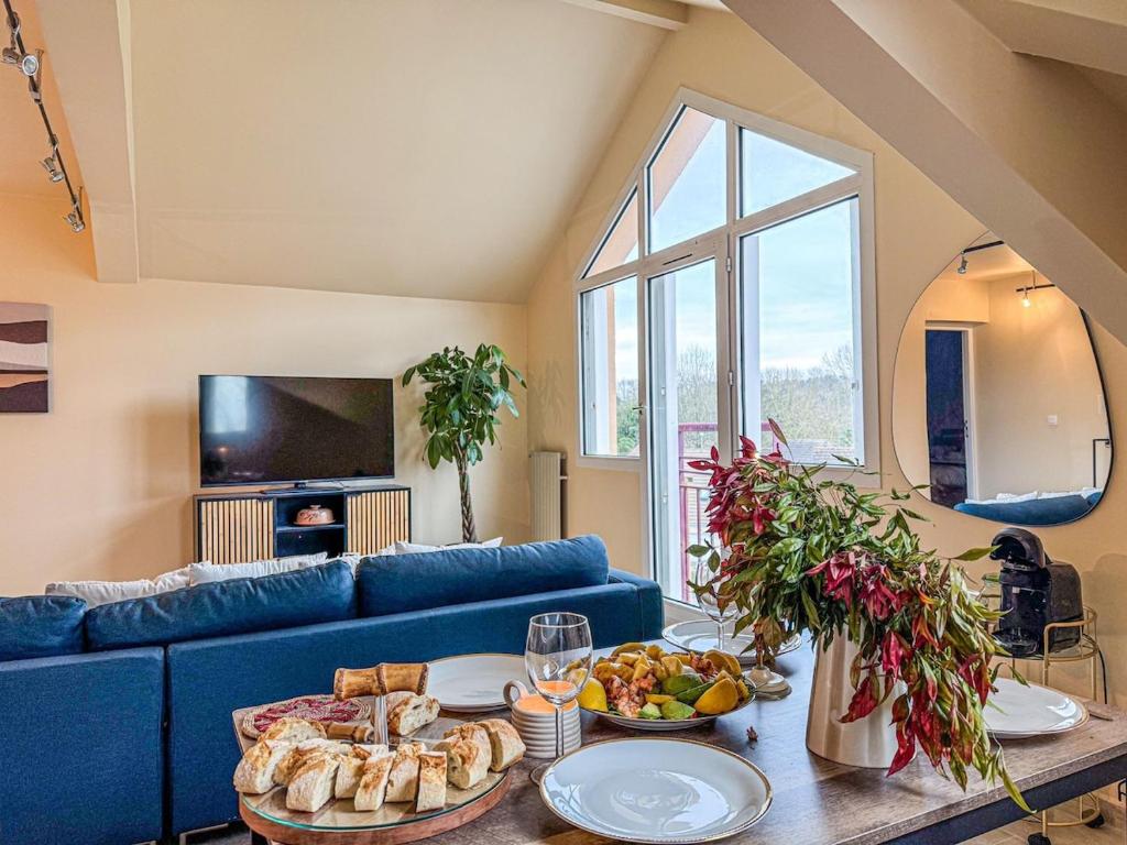 - un salon avec un canapé bleu et une table avec de la nourriture dans l'établissement Havre de Tranquillité Proche Pau, à Billère