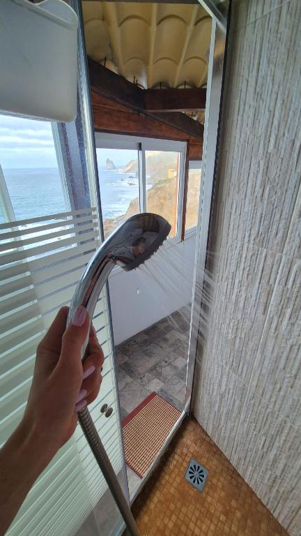 a person holding a shower head in a room at Casa lucas in Almáciga