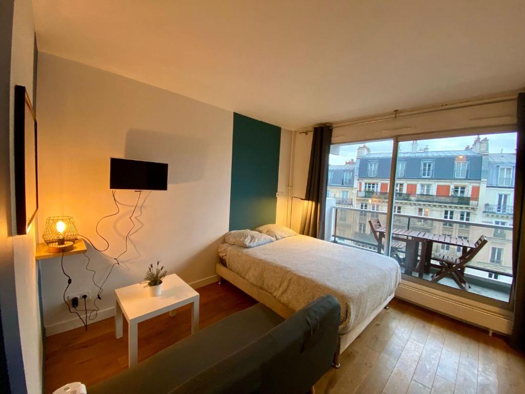 une chambre avec un lit et une grande fenêtre dans l'établissement Appartement Censier Monge, à Paris