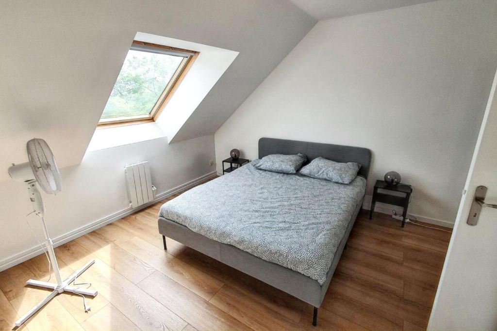 a bedroom with a bed and a large window at Charmant appartement à Magny-le-Hongre, 35 m², au calme in Magny-le-Hongre