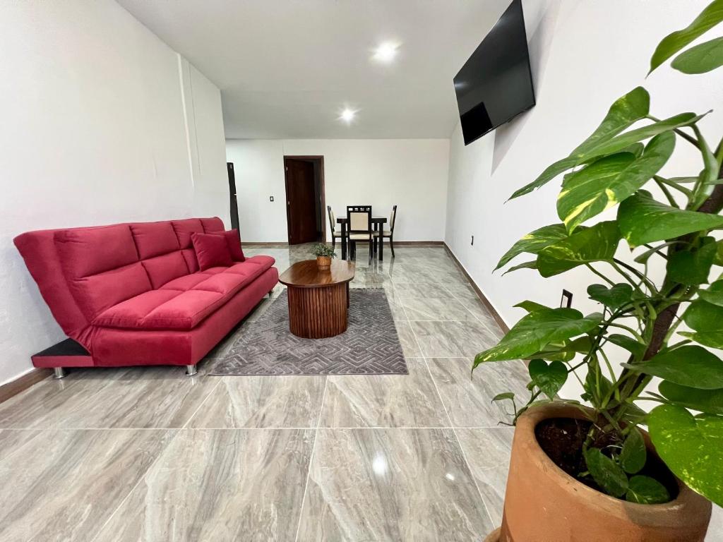 un soggiorno con un divano rosso e un tavolo di Huitzilin Hostal a Brisas de Zicatela