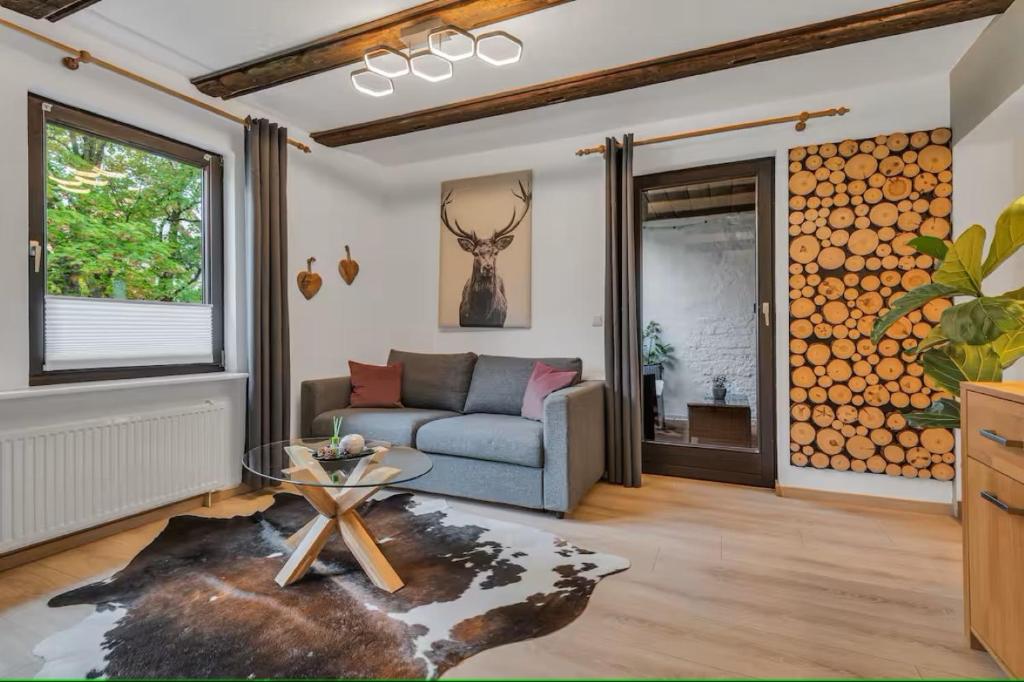 a living room with a couch and a glass table at HIRSCH Stadt Apartment 2 - Terrasse mit Flussblick - Parkplatz in Bad Harzburg