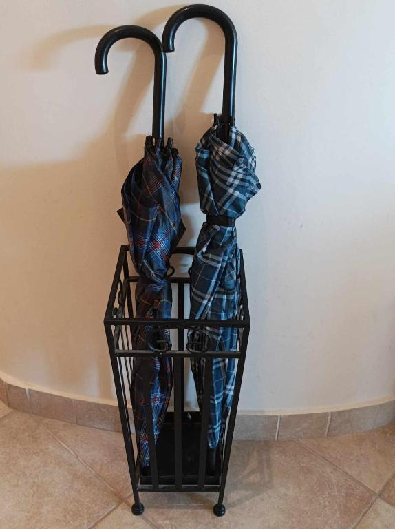 two umbrellas in a rack next to a wall at Breathe in Delphi - Spacious 3BR Apt with View in Delphi