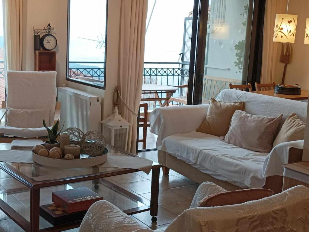 a living room with a white couch and a table at Breathe in Delphi - Spacious 3BR Apt with View in Delphi