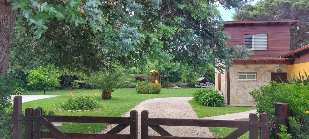 a garden with a wooden fence and a playground at Casas Catalina del Mar in Colonia Chapadmalal