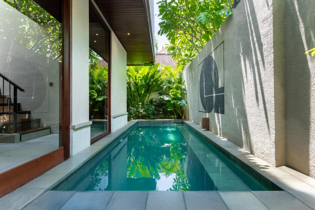 an infinity pool in the backyard of a house at Raya Villa by Betterplace in Canggu