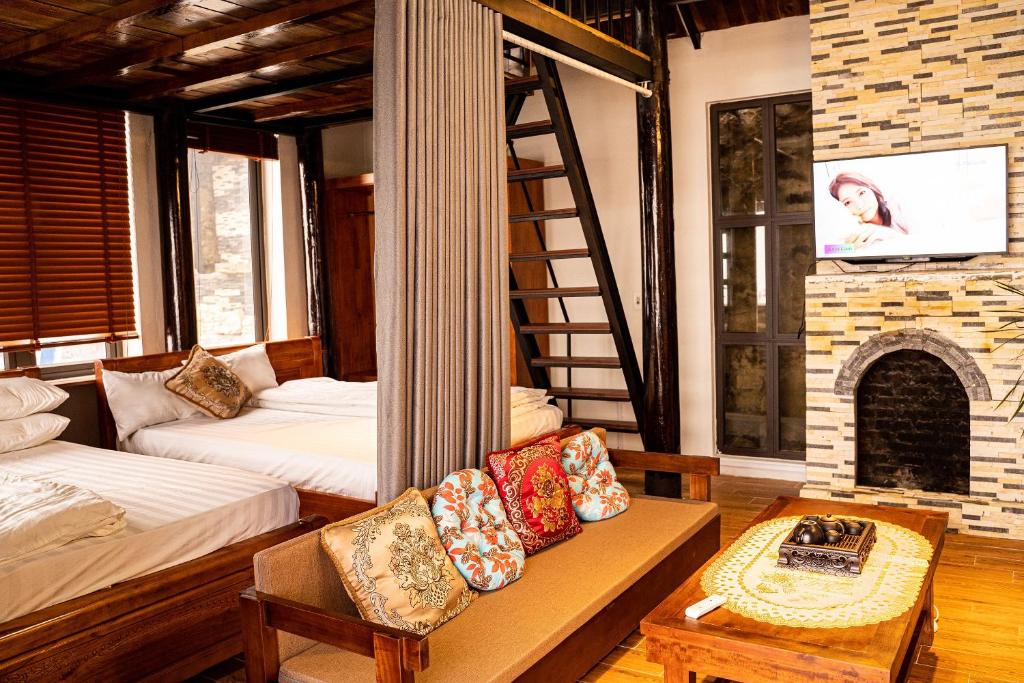 a living room with two beds and a fireplace at Chuồn Chuồn Villa Homestay Tam Đảo in Tam Ðảo