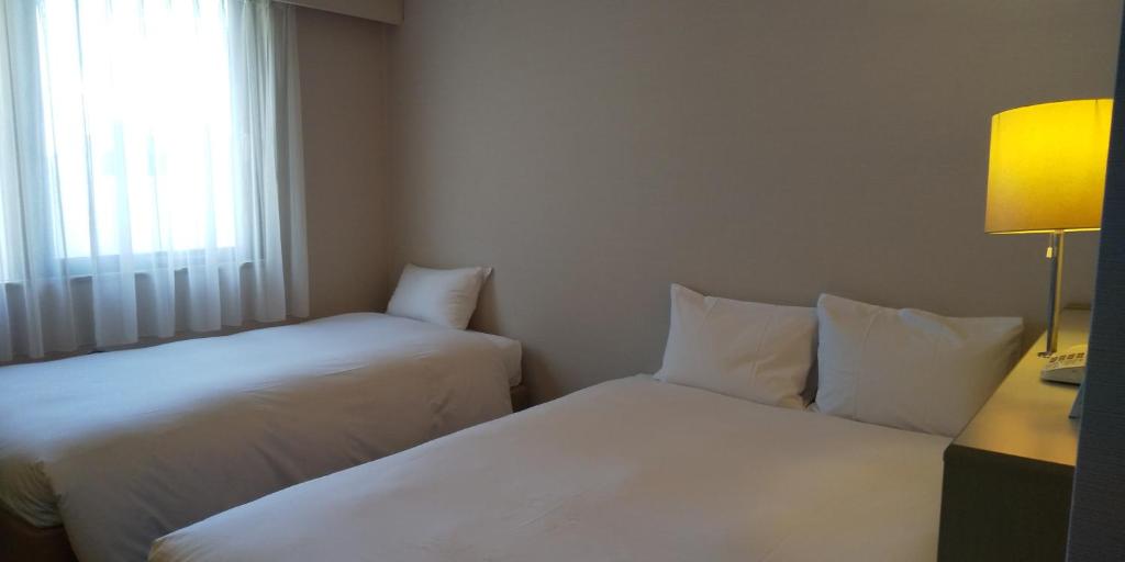 Postel nebo postele na pokoji v ubytování Hotel Crown Hills Sagamihara